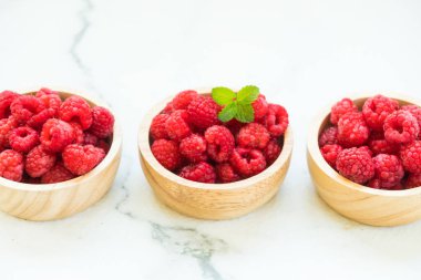 Kırmızı rasberries meyve masada ahşap kase