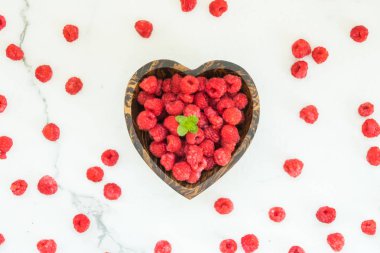 Kırmızı ahududu meyve masada ahşap kase