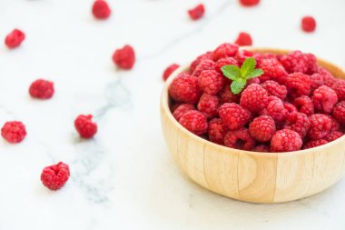 Kırmızı ahududu meyve masada ahşap kase