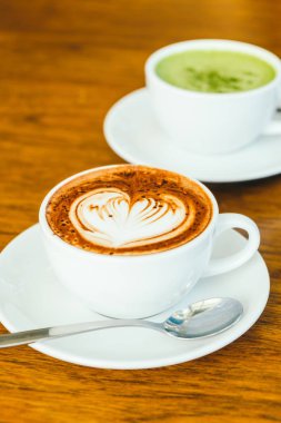 ahşap masa üzerinde beyaz fincan sıcak çikolatalı latte