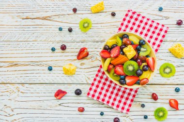 Kivi çilek üzüm ve diğer ahşap masa - filtre işleme üzerinde kase ile karışık ve çeşitli meyve