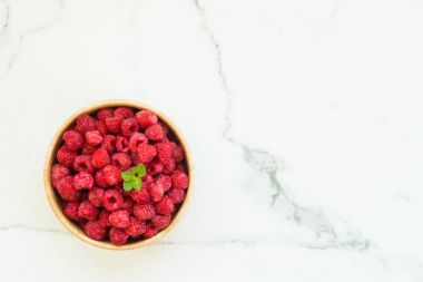 Kırmızı ahududu meyve masada ahşap kase