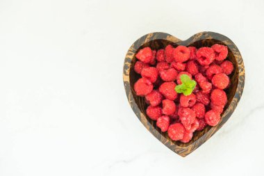 Kırmızı ahududu meyve masada ahşap kase