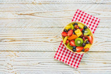 Kivi çilek üzüm ve diğer ahşap masa - filtre işleme üzerinde kase ile karışık ve çeşitli meyve