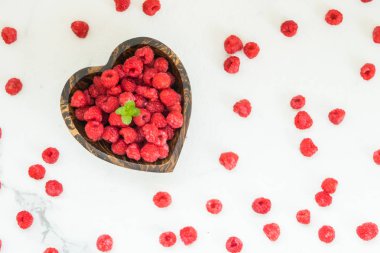 Kırmızı ahududu meyve masada ahşap kase