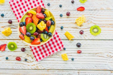 Kivi çilek üzüm ve diğer ahşap masa - filtre işleme üzerinde kase ile karışık ve çeşitli meyve