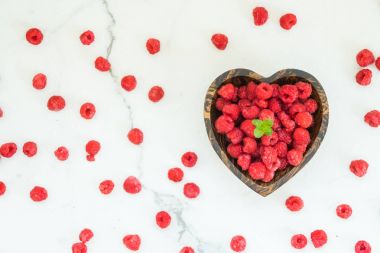 Kırmızı ahududu meyve masada ahşap kase