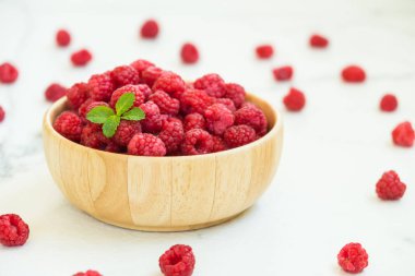 Kırmızı ahududu meyve masada ahşap kase