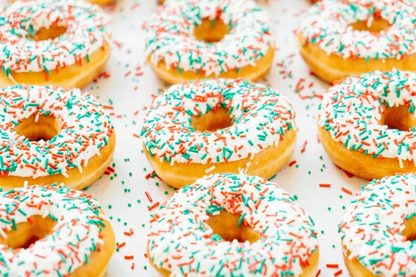 Donuts with white chocolate cream and sprinkles sugar