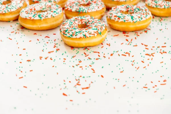 Donuts with white chocolate cream and sprinkles sugar