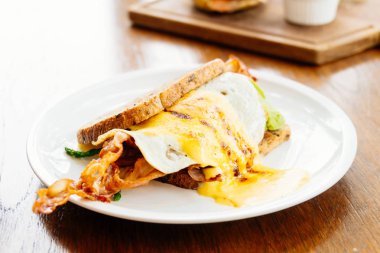 Avokado bacon ve beyaz tabak içinde kuşkonmaz ile sandviç