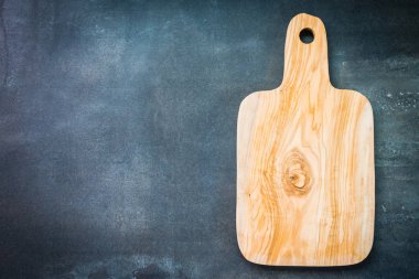 Siyah taş zemin üzerine ahşap kesme tahtası