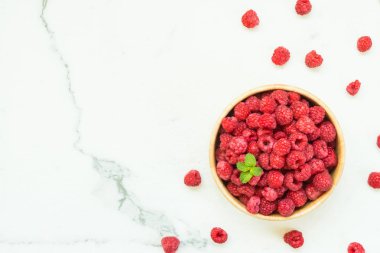 Kırmızı ahududu meyve masada ahşap kase