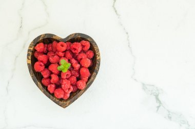 Kırmızı ahududu meyve masada ahşap kase