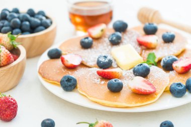 Sağlıklı kahvaltı gözleme yaban mersini ve çilek meyve ile taş tablo arka plan üzerinde ayarlayın.