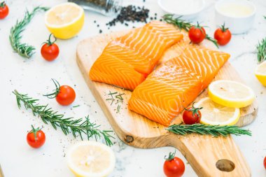 Limon domates ve diğer madde - sağlıklı gıda tarzı ahşap kesme tahtası üzerinde ham ve taze somon eti fileto