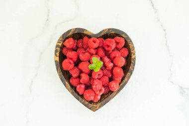 Kırmızı ahududu meyve masada ahşap kase