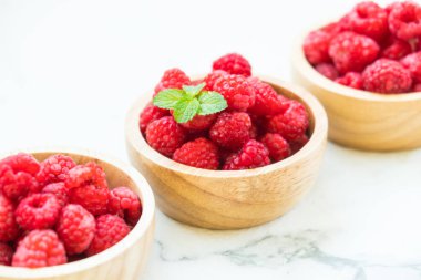 Kırmızı ahududu meyve masada ahşap kase