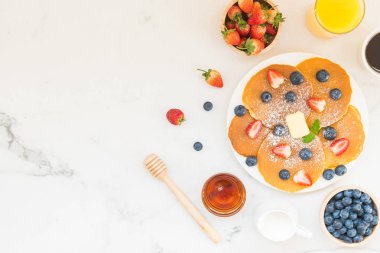 Sağlıklı kahvaltı gözleme yaban mersini ve çilek meyve ve siyah kahve, süt ve portakal suyu ile beyaz taş tablo arka plan üzerinde ayarla