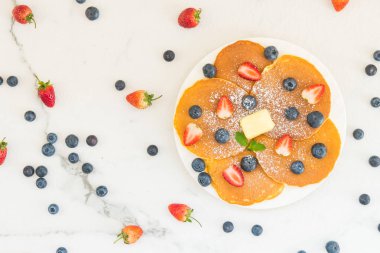 Sağlıklı kahvaltı gözleme yaban mersini ve çilek meyve ile taş tablo arka plan üzerinde ayarlayın.