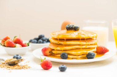 Sağlıklı kahvaltı kümesiyle gözleme ve Granola yaban mersini ve çilek ve siyah kahve, süt ve portakal suyu beyaz taş masa arka plan