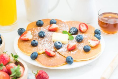 Sağlıklı kahvaltı gözleme yaban mersini ve çilek meyve ve siyah kahve, süt ve portakal suyu ile beyaz taş tablo arka plan üzerinde ayarla