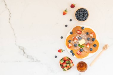 Sağlıklı kahvaltı gözleme yaban mersini ve çilek meyve ile taş tablo arka plan üzerinde ayarlayın.