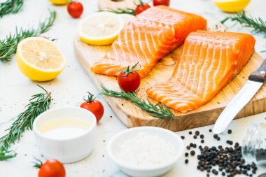 Limon domates ve diğer madde - sağlıklı gıda tarzı ahşap kesme tahtası üzerinde ham ve taze somon eti fileto