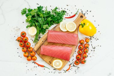 Sebze ve yemek pişirmek için madde ile ahşap kesme tahtası üzerinde ham ton balığı filetosu et