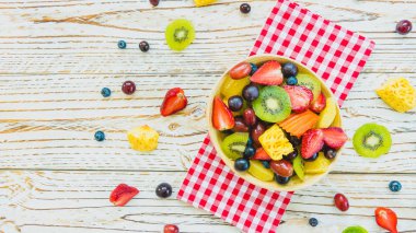 Kivi çilek üzüm ve diğer ahşap masa - filtre işleme üzerinde kase ile karışık ve çeşitli meyve