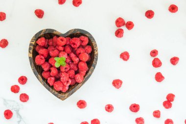 Kırmızı ahududu meyve masada ahşap kase