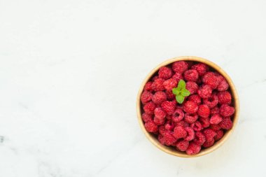 Kırmızı ahududu meyve masada ahşap kase