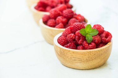 Kırmızı ahududu meyve masada ahşap kase