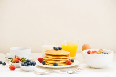 Sağlıklı kahvaltı kümesiyle gözleme ve Granola yaban mersini ve çilek ve siyah kahve, süt ve portakal suyu beyaz taş masa arka plan