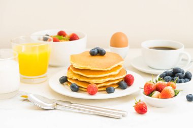 Sağlıklı kahvaltı kümesiyle gözleme ve Granola yaban mersini ve çilek ve siyah kahve, süt ve portakal suyu beyaz taş masa arka plan