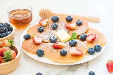 Sağlıklı kahvaltı gözleme yaban mersini ve çilek meyve ile taş tablo arka plan üzerinde ayarlayın.