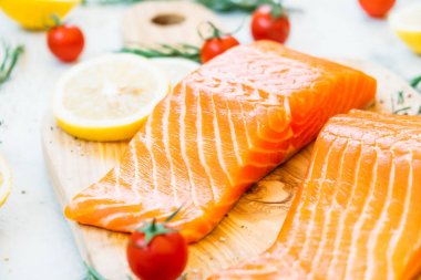 Limon domates ve diğer madde - sağlıklı gıda tarzı ahşap kesme tahtası üzerinde ham ve taze somon eti fileto