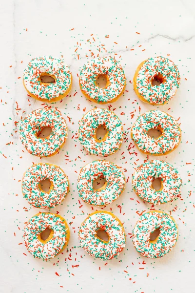 Donuts with white chocolate cream and sprinkles sugar on top - Unhealthy food style