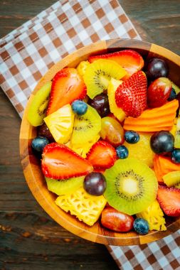 Kivi çilek üzüm ve diğer ahşap masa - filtre işleme üzerinde kase ile karışık ve çeşitli meyve