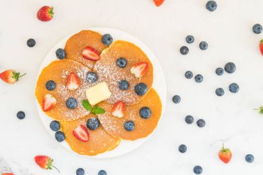 Sağlıklı kahvaltı gözleme yaban mersini ve çilek meyve ile taş tablo arka plan üzerinde ayarlayın.