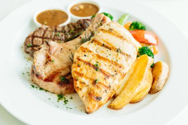 Izgara tavuk göğsü ve sığır eti biftek ve sebze beyaz tabak içinde pirzola