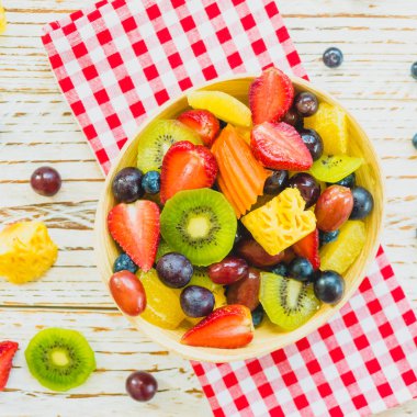 Kivi çilek üzüm ve diğer ahşap masa - filtre işleme üzerinde kase ile karışık ve çeşitli meyve