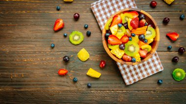 Kivi çilek üzüm ve diğer ahşap masa - filtre işleme üzerinde kase ile karışık ve çeşitli meyve