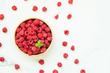 Kırmızı ahududu meyve masada ahşap kase