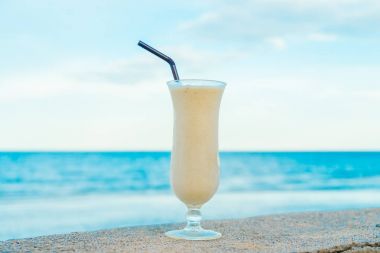 Muz smoothies cam deniz ve okyanus arka plan ile içme buz