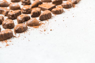 Şekerli tatlı koyu çikolata parçaları ve beyaz taş zemin üzerine kakao tozu