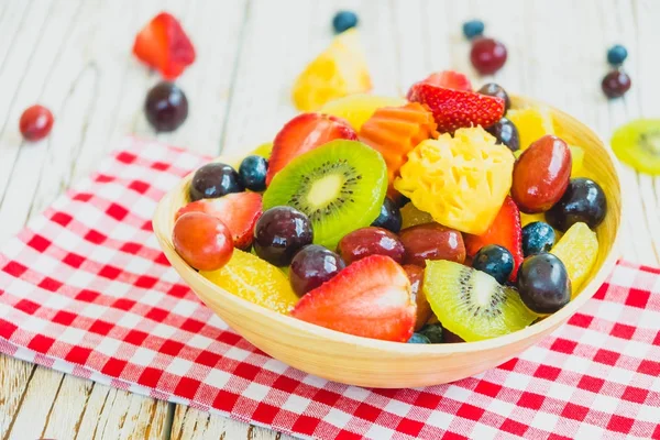 Mixed and assorted fruits with kiwi strawberry grape and other in bowl on wood table - Filter Processing