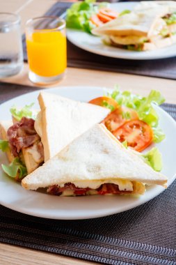 Club ekmek ve sandviç kahvaltı için beyaz tabakta sebze ile