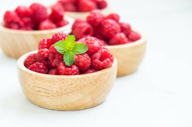 Kırmızı ahududu meyve masada ahşap kase