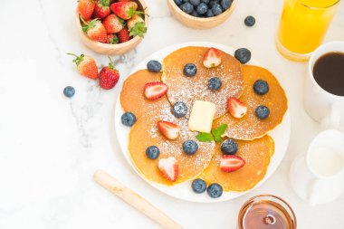 Sağlıklı kahvaltı gözleme yaban mersini ve çilek meyve ve siyah kahve, süt ve portakal suyu ile beyaz taş tablo arka plan üzerinde ayarla